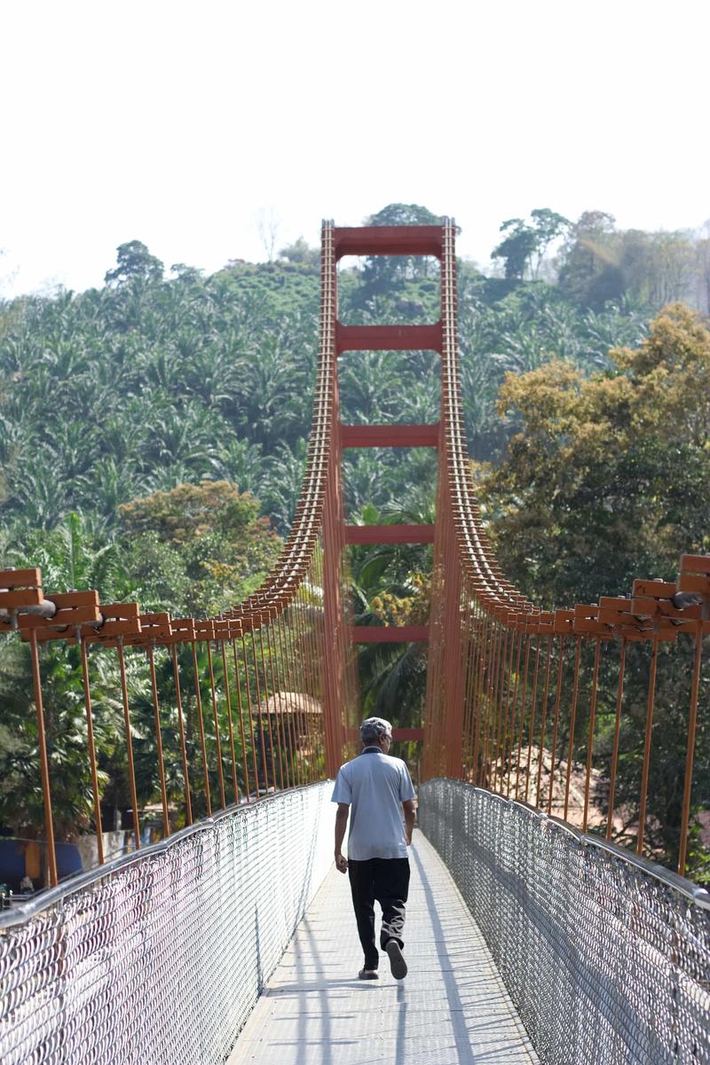 Father Xavier, crossing a bridge at Athirappilly Falls, Ernakulam, Kerala, India