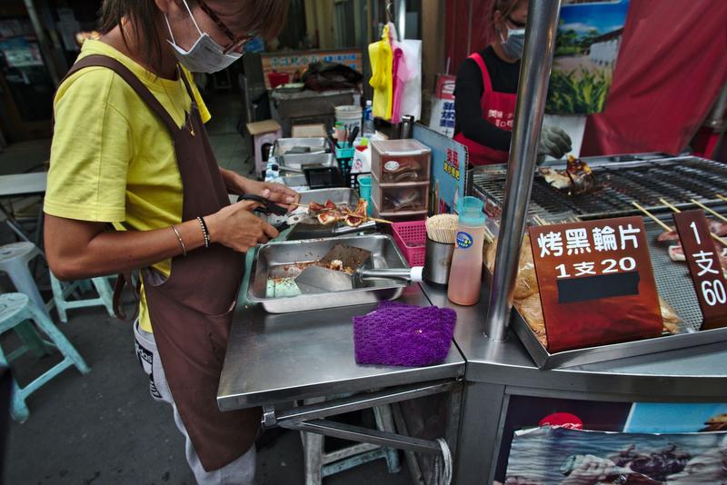 Cutting up squid with scissors on Cijin Island, Taiwan