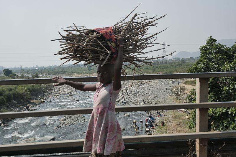 Kids carrying branch bundles on their heads, Uganda