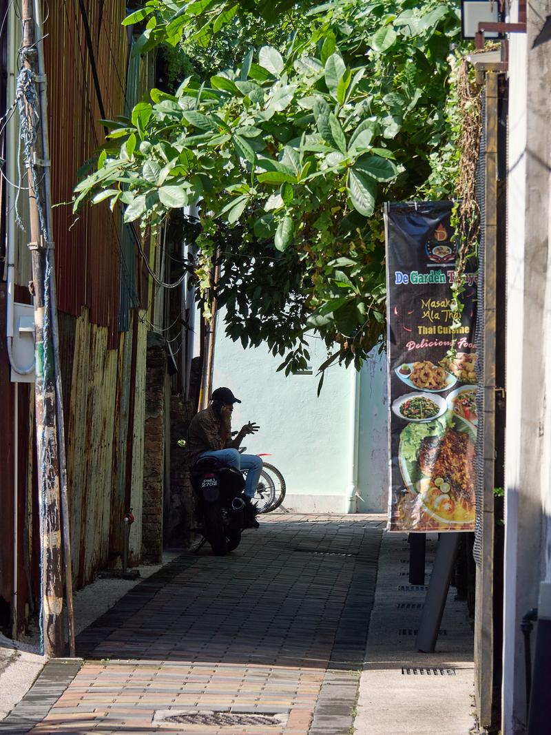 Look through allyway, hand gestures, strong light and shadows, Penang, Malaysia