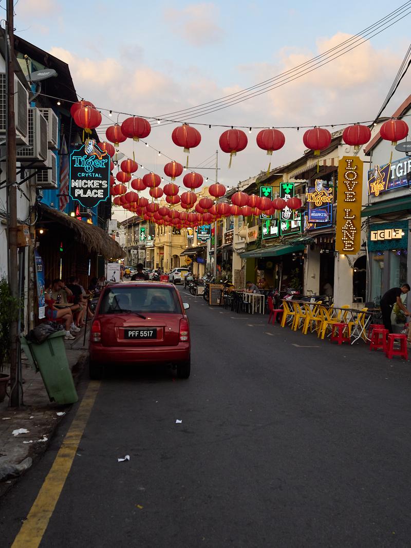 Lanterns strung over the road, striking blue-green building, Penang, Malaysia